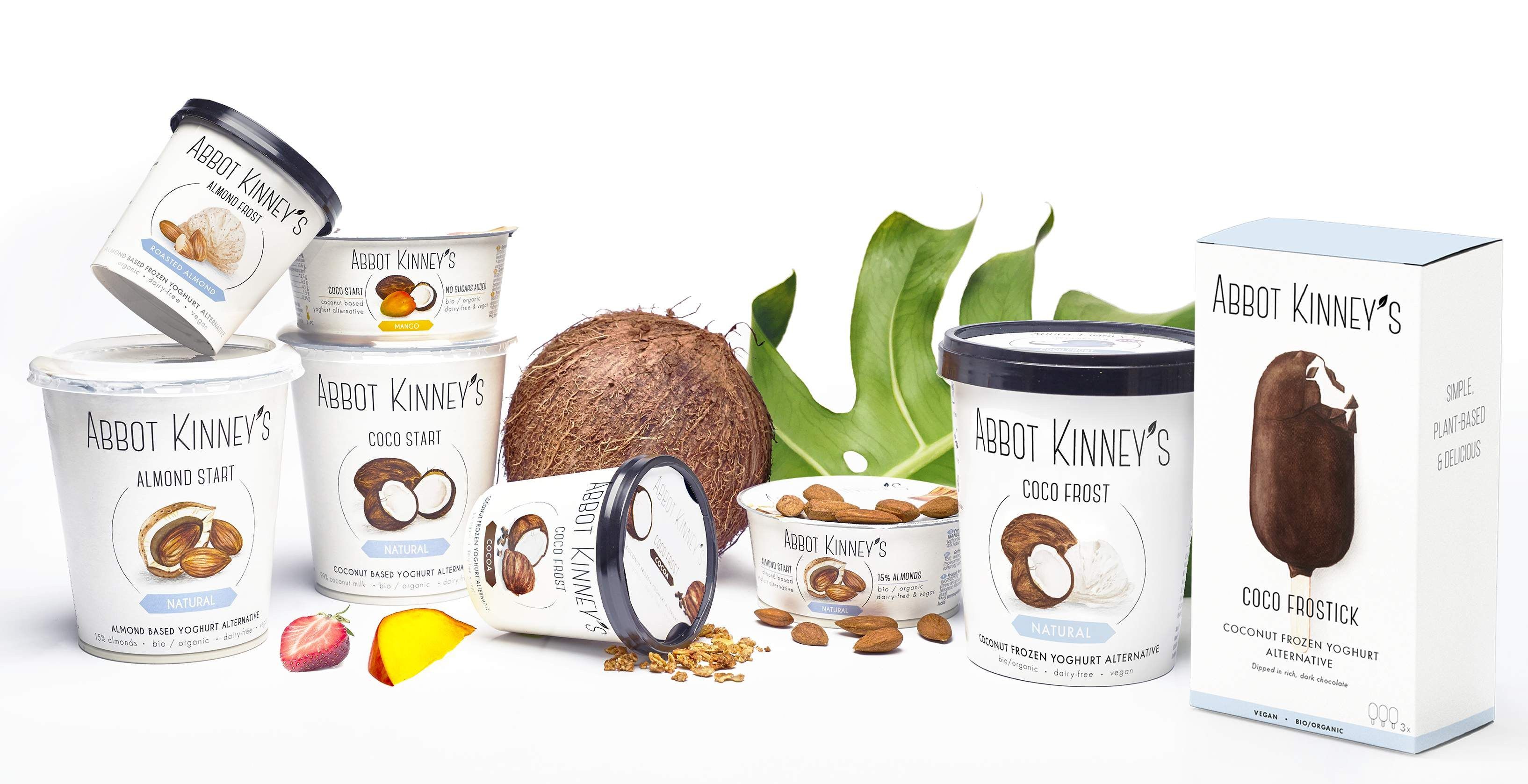 De productfamilie van Abbot Kinney’s: plantaardige yoghurtalternatieven met kokos en amandel en de Coco Frostick, tussen kokosnoot, amandelen en bladeren.